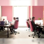 People working in pink Hugo Highback chairs in an office