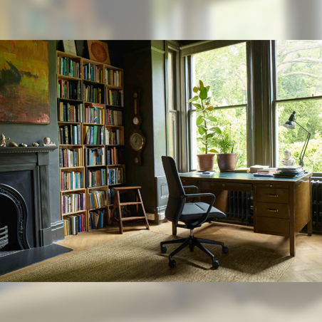 The black Senator Qdos High Back Chair in a home study setting with a fireplace